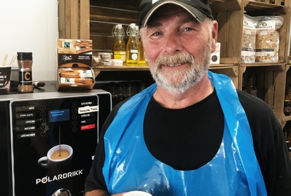 Mann på gård med kaffemaskin