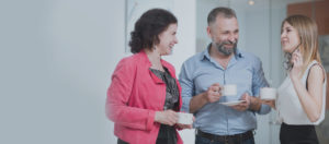 folk på kontoret drikker kaffe og smiler