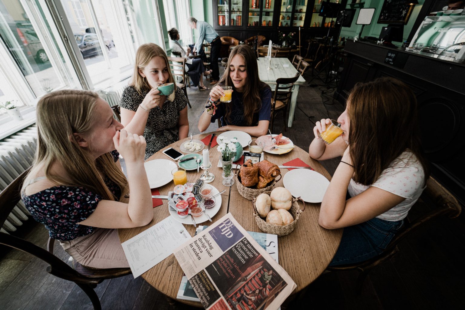 damer drikker kaffe rundt bord