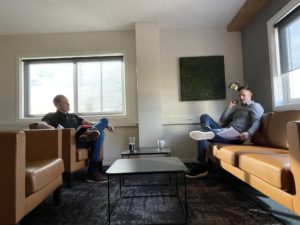 2 menn sitter og snakker