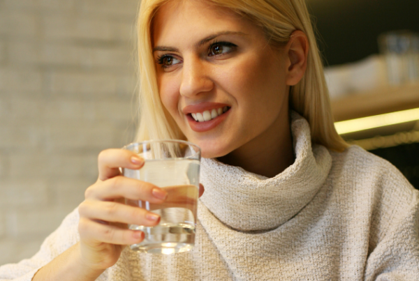 en glad dame som drikke friskt vann
